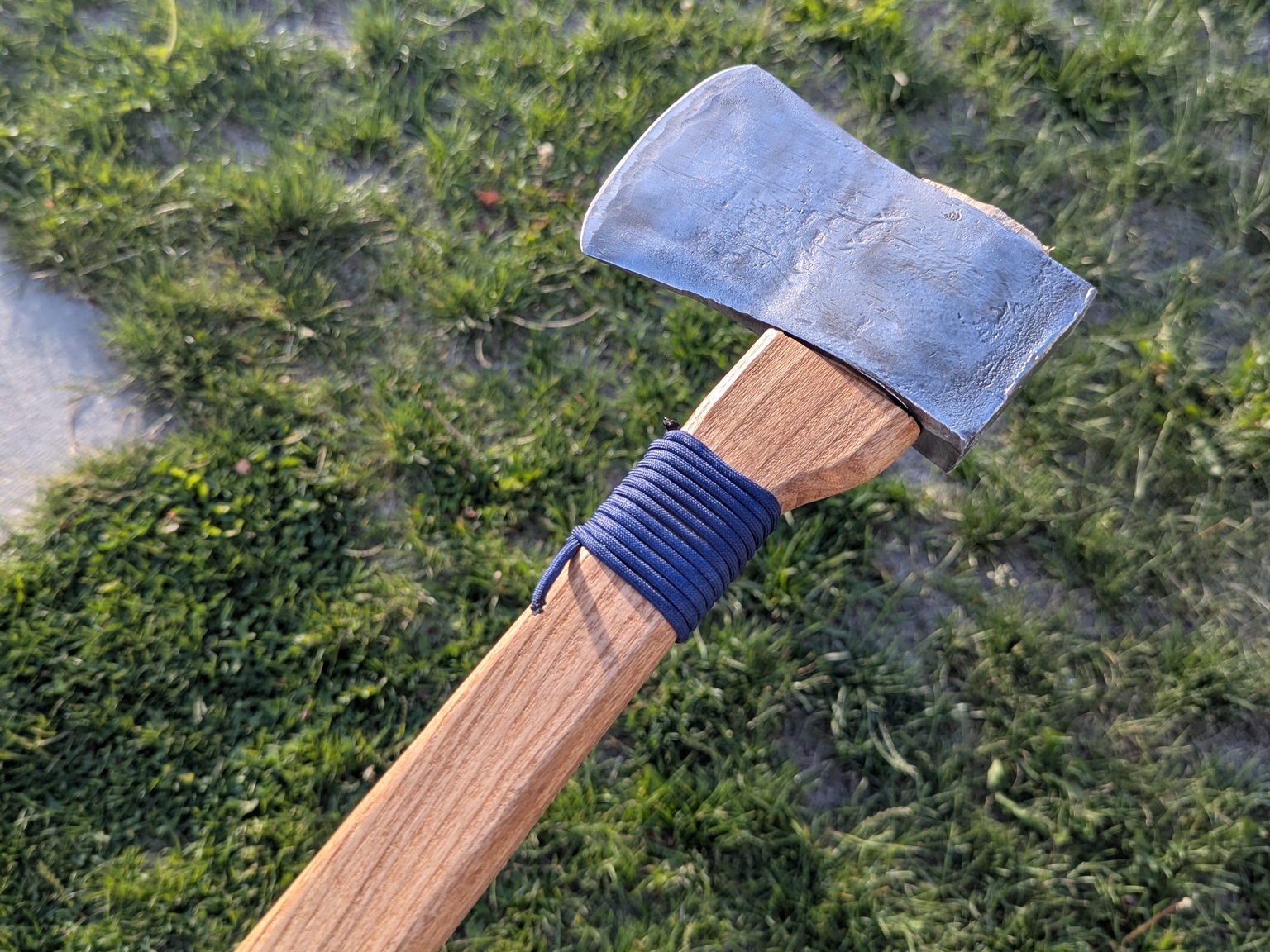 a shiny but aged-looking axehead attached to a brand new handle